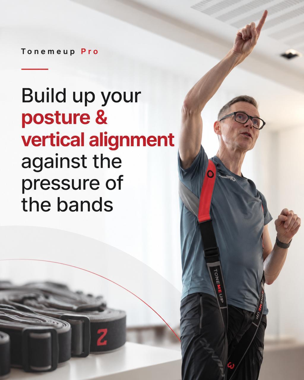 Holger demonstrating posture and vertical alignment with a TONEMEUP resistance harness, one arm raised